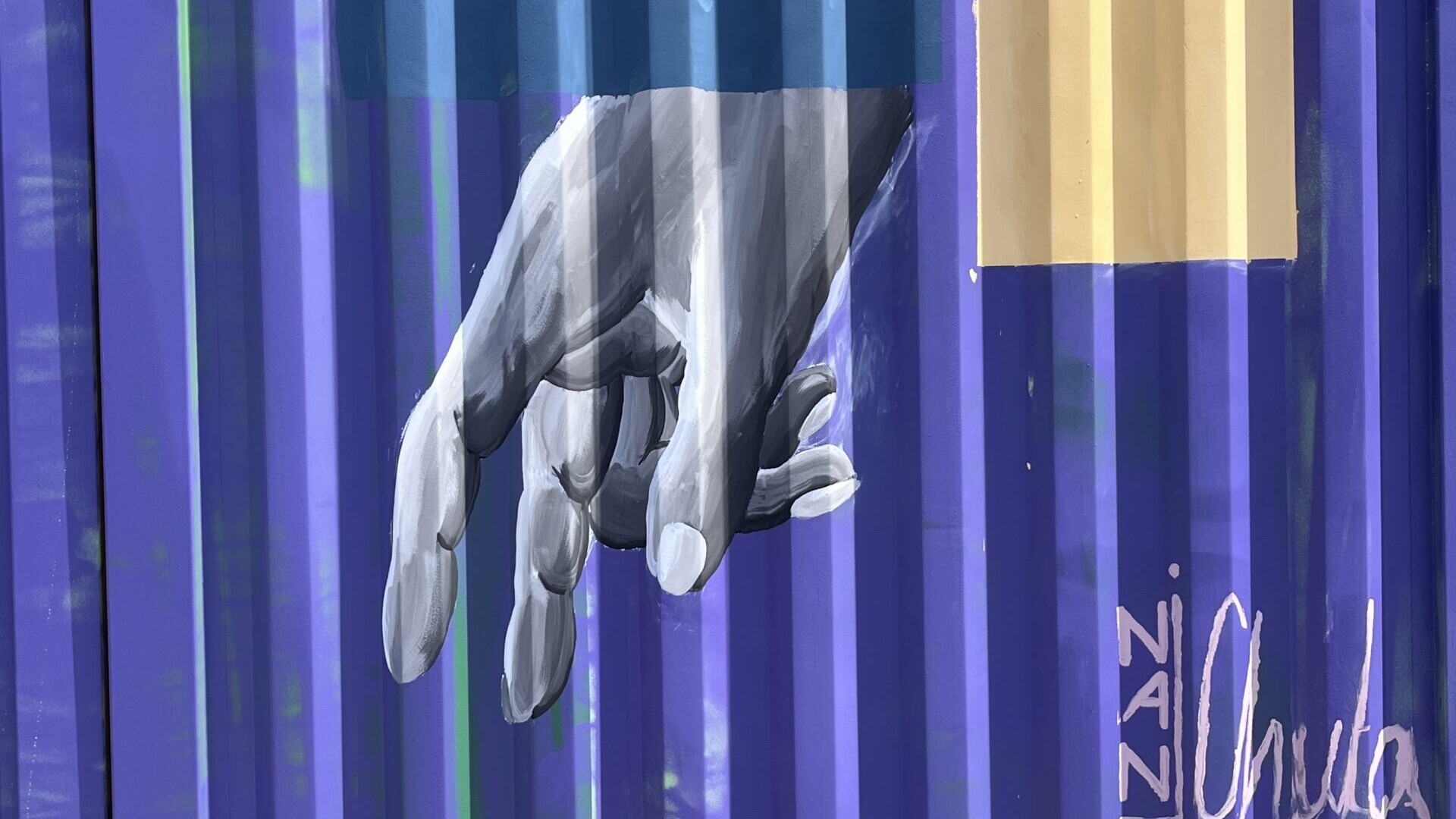 Graffiti: Hand in Grauabstufungen auf blauen Container